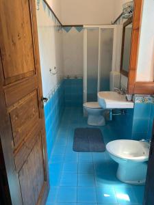 bagno piastrellato blu con 2 servizi igienici e lavandino di Residence Salvatore a San Salvatore
