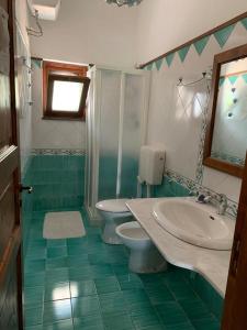 bagno con lavandino, servizi igienici e specchio di Residence Salvatore a San Salvatore