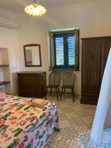 Residence Salvatore في San Salvatore: غرفة نوم بسرير وخزانة وكرسيين