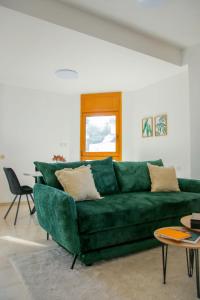 a green couch in a living room with a table at Meir Dizengoff Residence with Shelter in Tel Aviv