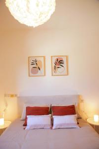 een slaapkamer met een bed en twee foto's aan de muur bij Meir Dizengoff Residence with Shelter in Tel Aviv