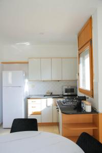 a kitchen with white cabinets and a white refrigerator at Meir Dizengoff Residence with Shelter in Tel Aviv