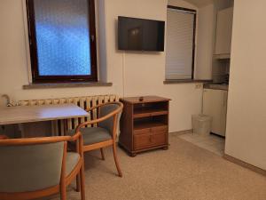 Zimmer mit einem Tisch, Stühlen und einem TV in der Unterkunft Monteurzimmer 