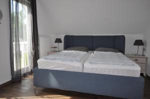 a large bed in a room with a large window at Haus Annette in Glowe