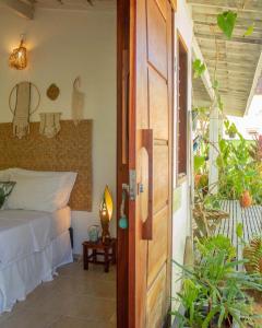a bedroom with a bed next to a door at Pousada Tangerina in Icaraí