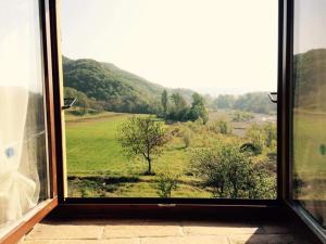 a window with a view of a green field at Cascina Formighezzo in Arquata Scrivia