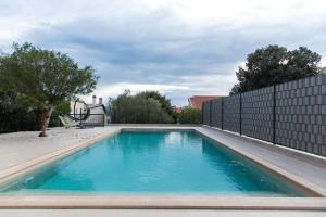 basen w ogrodzie z ogrodzeniem w obiekcie Villa Anchor w mieście Zadar