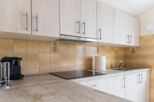 kuchnia z białymi szafkami i zlewem w obiekcie Villa Anchor w mieście Zadar