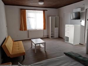 a living room with a couch and a table and a window at Parti Sétány Vendégház in Balatonkenese