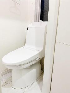 a bathroom with a white toilet in a room at Shinokubo guest house in Tokyo