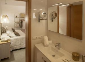 a bathroom with a sink and a mirror and a bed at Stella Maris - Formentera Break in Playa Migjorn