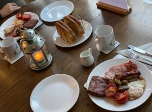 a wooden table topped with plates of breakfast foods at Forsinard Lodge in Forsinard
