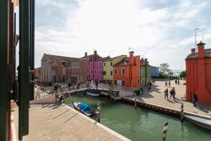 a view of a canal with colorful buildings and a bridge at Wondrous Palazzetto 1619 in Magical Burano Island in Burano