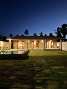 a large house with a large yard at night at Casa Palma in São Miguel do Gostoso