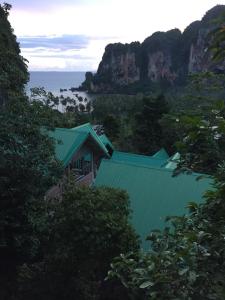 Garden View Resort Tonsai في شاطئ تونساي: مبنى بسقف أخضر بجوار المحيط