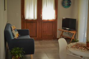 sala de estar con sofá azul y TV en Casa Lali en Lago Puelo