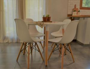 una mesa de comedor con sillas blancas alrededor en Casa Lali en Lago Puelo