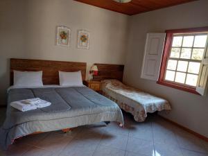 een slaapkamer met een bed en een raam bij Casa do Aconchego in Tiradentes