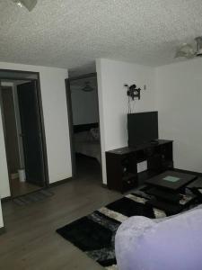 a living room with a couch and a tv at Apartaestudio amoblado, Edificio el eden 148 in Bogotá