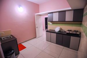 a kitchen with pink and black cabinets and a stove at zanbaq residency in Vythiri