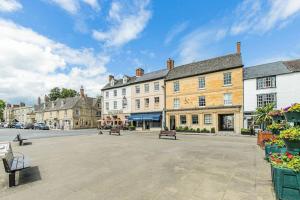 a street in a town with buildings and benches at Oxfordshire Living - The Vanbrugh Apartment - Woodstock in Woodstock