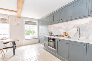 a kitchen with gray cabinets and a counter top at Oxfordshire Living - The Vanbrugh Apartment - Woodstock in Woodstock