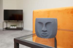 einem Glastisch mit einer Skulptur eines Gesichts darauf in der Unterkunft Prime Location & Free Parking Stylish 3-Bed Home in Leicester