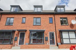 ein rotes Backsteinhaus mit schwarzen Fenstern in der Unterkunft Prime Location & Free Parking Stylish 3-Bed Home in Leicester