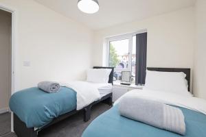 a bedroom with two beds and a window at Prime Location & Free Parking Stylish 3-Bed Home in Leicester
