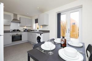 a kitchen and dining room with a table and chairs at Prime Location & Free Parking Stylish 3-Bed Home in Leicester
