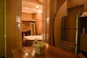 第比利斯Apartment Elizabeth in Old Tbilisi的一间带桌子和冰箱的房间以及一间卧室