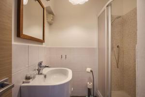 La salle de bains blanche est pourvue d'un lavabo et d'une douche. dans l'établissement Claire - Sweet Dreams in Florence, à Florence