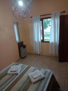 1 dormitorio con 2 toallas en una cama con ventana en UAKEN CABAÑAS en El Calafate