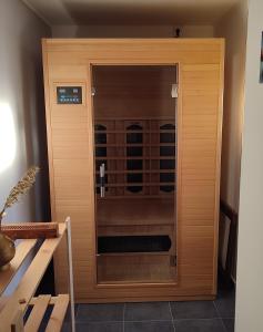 Apartmán v prírode s vlastnou saunou في مارتين: قبو نبيذ خشبي مع باب زجاجي