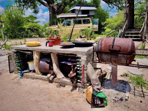 - une table en pierre avec un grill et un pot dans l'établissement Eselbe Camp Backpackers, à Nata