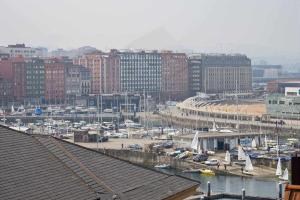a view of a harbor with boats and buildings at Las Gaviotas Playa By Silastur in Gijón