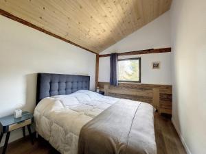 sypialnia z dużym łóżkiem i oknem w obiekcie Green Marmottes Chalet - 12 personnes - Pied des pistes - Saint Jean D Aulps w mieście Saint-Jean-dʼAulps