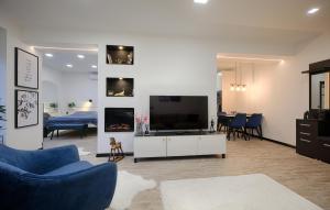 a living room with a couch and a tv and a table at Monos Apartman in Tatabánya