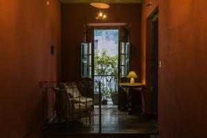 un couloir avec une chaise et une porte ouverte dans l'établissement Bahiacafé Hotel, à Salvador