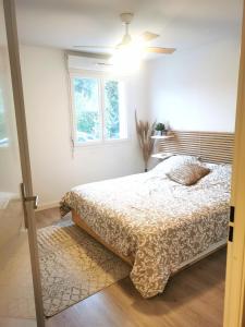 1 dormitorio con 1 cama y ventilador de techo en Capbreton Superbe appartement avec parking en Capbreton