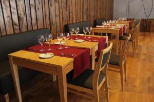 una fila de mesas de madera con copas de vino. en Lousada Country Hotel en Lousada