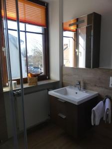 een badkamer met een wastafel, een spiegel en een raam bij Bayerischer Hof in Rothenburg ob der Tauber