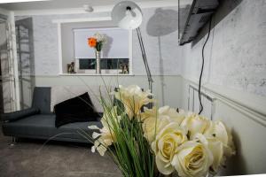 a living room with a couch and a vase of flowers at Abbeygreen House in Lanark