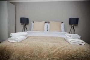 1 dormitorio con 1 cama grande y toallas. en Abbeygreen House en Lanark