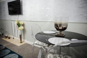 a table with a glass of wine and two chairs at Abbeygreen House in Lanark