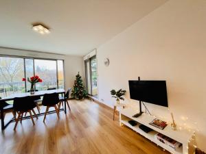 - un salon avec une table, une télévision et un arbre de Noël dans l'établissement Friendly Bean, à Cachan