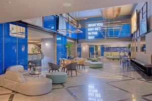 a lobby of a restaurant with chairs and tables at NH Napoli Panorama in Naples