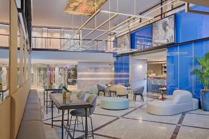 a lobby of a store with tables and chairs at NH Napoli Panorama in Naples