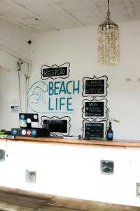 um bar com um sinal de vida de praia numa parede em Beach Life Porto de Galinhas em Porto de Galinhas