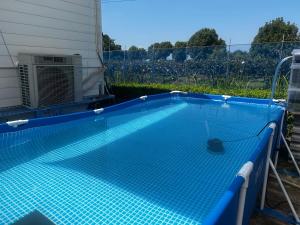 una piscina con suelo de baldosa azul en Glamping Village LEAF, en Mashiki